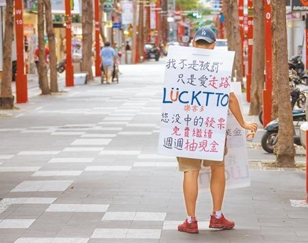 全國三級警戒確定延至7月26日,一位民眾為生計背著看板走在西門町鬧區賺取微薄薪酬。勞動部16日公布最新的無薪假統計,目前總計有2,704家企業,3萬1,980人正在實施無薪假,家數續創歷史新高。(羅永銘攝)