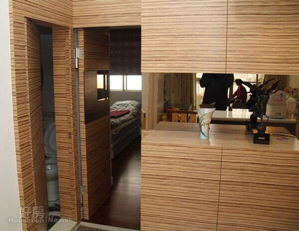 
3.廚房區的木紋牆面導入隱藏式概念，將三間臥房與一間衛浴室巧妙藏起來。