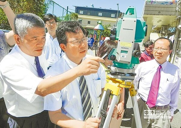 桃園市政府工務局20日在八德區廣興社區活動中心進行老屋健檢示範作業,市長鄭文燦(中)使用經緯儀示範健檢作業。(工務局提供)