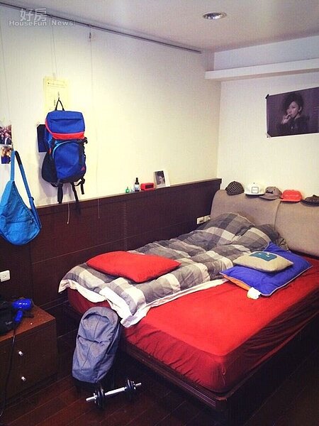 9.臥房牆上貼著偶像孫燕姿的海報,床組則是咖啡色系搭配紅色床罩。