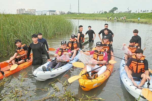 中華醫事科大昨將孔雀魚、大肚魚等投入仁德滯洪池。 記者綦守鈺/攝影