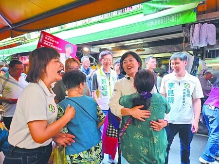 
民進黨新北市長參選人蘇巧慧（左三）12日到板橋青翠市場掃街拜票，受到熱情民眾的擁抱。（張鎧乙攝）
