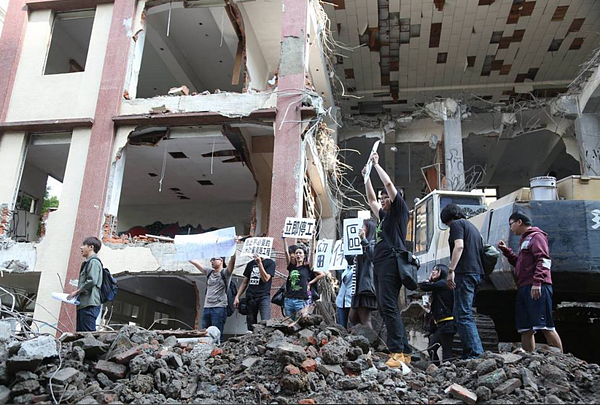 民間團體以肉身擋車，捍衛南港瓶蓋工廠。（翻攝自守護南港瓶蓋工廠團體臉書）