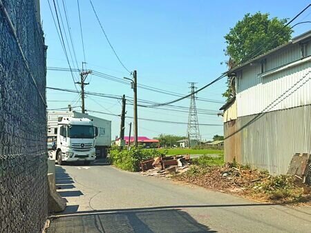 
屏東縣新園鄉媽祖路一處路口常有大型車輛出入，因民眾購地後興建圍牆，導致大車進出困難，考驗駕駛技術。（紀爰攝）
