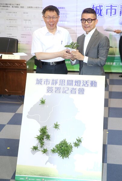 台北市政府昨天舉行「城市靜思」關燈活動簽署記者會，由台北市長柯文哲（左）與各企業代表簽署關燈活動參與意向書。 記者高彬原／攝影