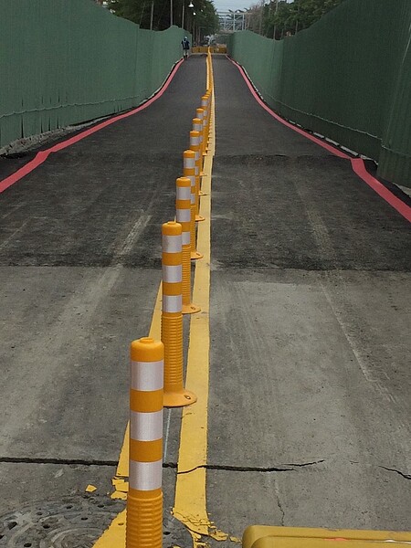 日前因為台電施工不慎導致大規模塌陷的高雄小港區中林路,經過搶修之後,原本將於今日中午開通的機車道,卻在颱風杜鵑來襲後,又出現裂痕及路面突起的狀況。(圖/立委林國正臉書)