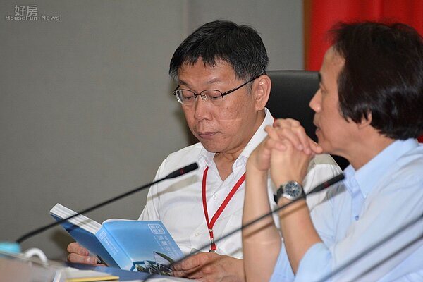 柯文哲於公共住宅委員會議中觀看邱復生的書。(好房網News記者 陳韋帆/攝影)