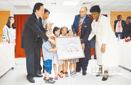 趙犁民董事長(左)與家扶小朋友獻上象徵台史二國攜手關懷弱勢、灌溉幼苗的畫作,給史瓦濟蘭副總理戴保羅伉儷。(陳世宗攝)