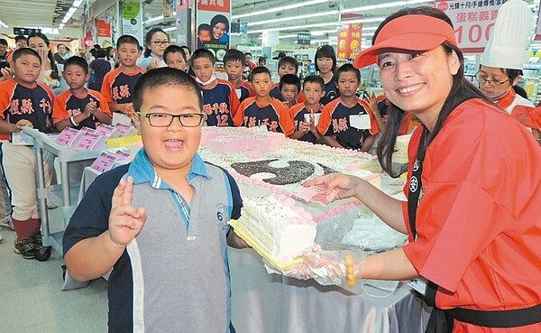 家樂福南投店經理林映秀(右)為第一位響應義賣的小朋友奉上國慶蛋糕。 記者紀文禮/攝影
