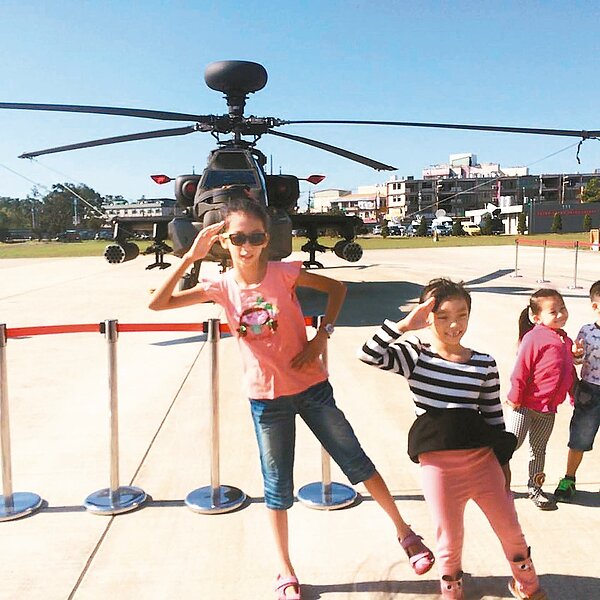 國防部順應民意，昨開放參觀陸軍航空特戰指揮部六○一旅阿帕契戰鬥直升機，不少民眾學李蒨蓉單腳站立、右手行禮招牌姿勢拍照。 圖／呂筱蟬