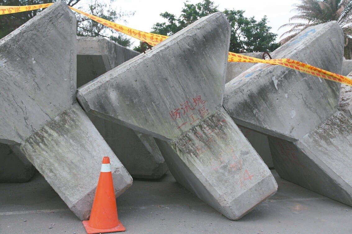 四湖鄉三條崙外海堤在杜鵑颱風來襲時潰堤,將在內防波堤鋪設消波塊,因與地主未完成協調,臨時堆置在一旁空地。 記者胡瑋芳/攝影