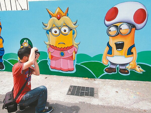 沙鹿區洛泉里彩繪牆以卡通人物「小小兵」為主軸,吸引不少遊客前往拍照。 記者余采瀅/攝影