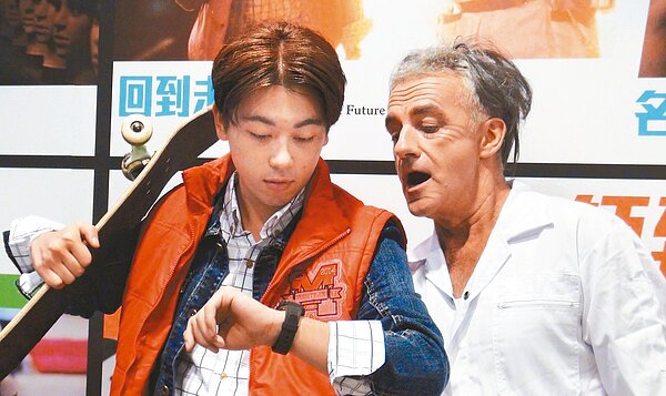 高市新總圖八樓變身為電影院,影迷扮成電影「回到未來二」的瘋狂博士與男主角看表,時間回到三十年前的十月廿一日。 記者徐如宜/攝影