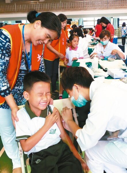 台中市府為了提升國小學童流感疫苗接種率，與9家醫院合作，連日到校園為學童打疫苗。圖為大勇國小學生接種流感疫苗。 記者趙容萱／攝影