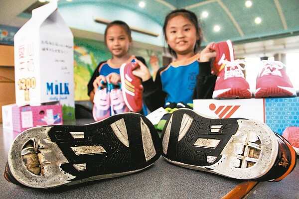 南安國小「夜光天使班」學童昨天收到中華道家人文協會送的新鞋,開心不已,終於可以擺脫磨破底的濕鞋了。 記者羅建旺/攝影