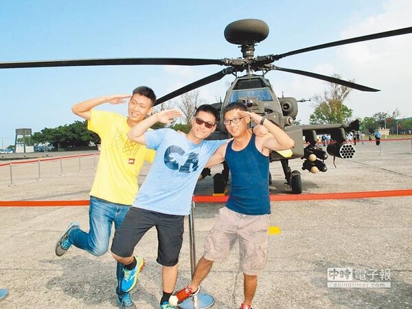 海軍左營營區24日開放參觀，民眾紛紛在阿帕契直升機前擺出藝人李蒨蓉的POSE合影。（中國時報呂素麗攝）
