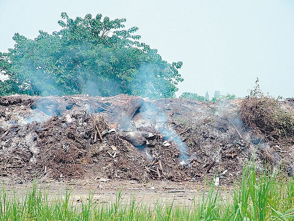 斗六市臨時垃圾轉運站旁空地遭民眾傾倒垃圾，起火悶燒。 記者陳雅玲／攝影