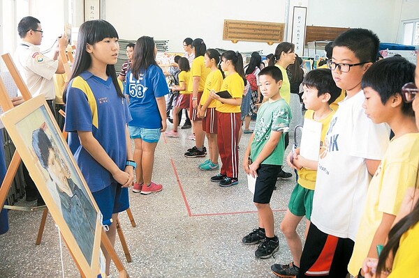 學童們擔任小小導覽員,為觀眾解說畫作,認真的態度不輸專業人士。 記者林麒瑋/攝影