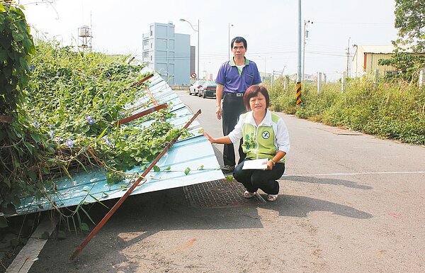 縣議員陳秋蓉(前)指颱風吹倒的鐵皮遲遲未修理,可能危害民眾安全。 記者凌筠婷/攝影