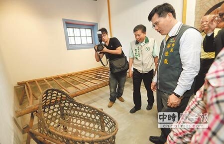 
台中市長林佳龍（右）參觀「瑞成堂」屋內設施，發現一個竹編嬰兒搖籃。（黃國峰攝）
 
