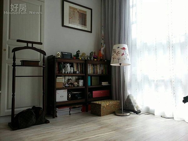 4.客廳的角落，有著深色系的矮櫃，上頭放著書，還有一些出國買回來的紀念品。
