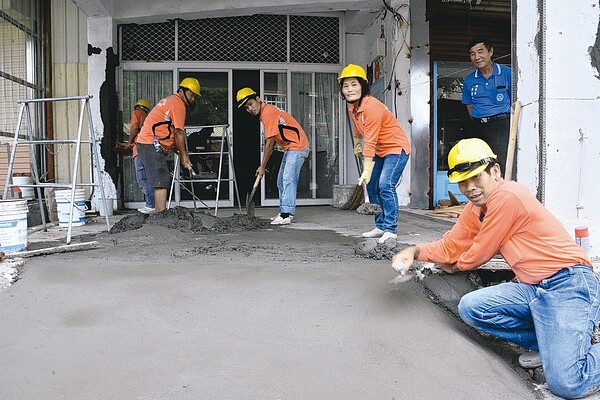 台南市泥水職業工會志工陳皆福（右）妻兒一家3口，進駐夢工場修繕房子。 記者吳淑玲／攝影