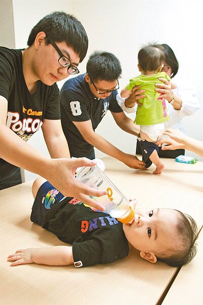 老爸也難為!圖為新手奶爸PK賽,新手爸爸為小朋友換尿布、餵奶。 報系資料照