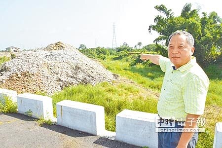 萬巒鄉長林碧乾指出,高達3層樓高的廢土堆就緊鄰大排水溝,若坍方會嚴重影響排水。(許智鈞攝)