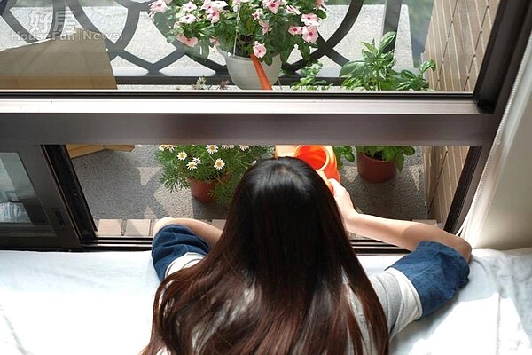 3. 小陽台種滿各種花草,但因為上方窗戶無法打開,因此必須像照片中這樣壓低身子澆水。