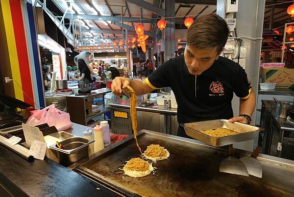 高雄市三民區建工夜市商場將於本周五20日開幕,第1排美食攤商們18日晚間已開始試營業。(王錦河攝)