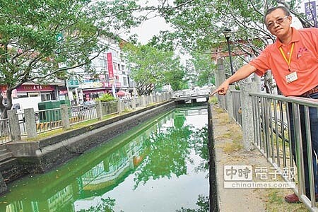 
東港鎮公所清潔隊長陳正峰，到場勘查大排水質變色狀況。（許智鈞攝）
 