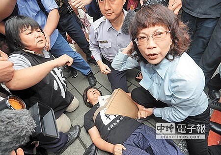 
　勞團抗議 爆發推擠　　國民黨副總統參選人王如玄（右）23日陪同黨籍立委登記參選，遇到關廠工人抗議，隨後要離開時發現有抗議民眾受傷倒地，原來已經上車準備離開的王如玄下車，探視受傷民眾，直到救護車到才離開。　　（圖文:趙雙傑）
 