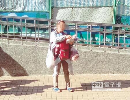 
女子胸前揹著小孩，在桃園火車站前賣東西維生。（甘嘉雯攝）
 