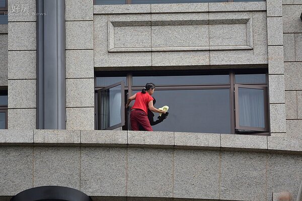 敦化南路上直擊疑似外傭未有任何安全措施,爬出窗外清洗窗戶及外牆。(好房網News記者 陳韋帆/攝影)