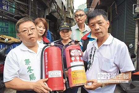 龍濱里長曾添發(右)、幸福里長郭冬賜(左)指出,三重幾乎每個里都有滅火器過期,等不到民政局協助更新。(陳宜加攝)