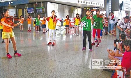 
圓夢了新竹縣竹北市興隆國小弦樂團30位小朋友，7日上午到高鐵新竹站大廳快閃演奏《小蘋果》等曲目，吸引旅客欣賞。（陳育賢攝）
 