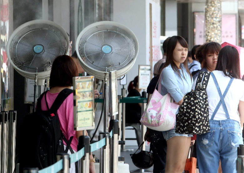 台北市上午高溫酷熱，一家餐飲店特別準備水霧扇，為在戶外等候進場的民眾消暑。 圖／屠惠剛攝影
