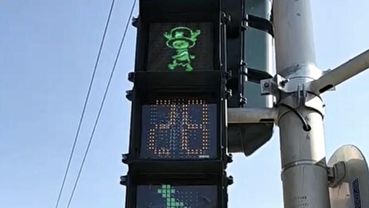 高雄市利用行人號誌加裝輔助顯示器,呈現活動主視覺或宣導交通,但特色號誌吸引人潮駐足拍照,民代憂心引發交通亂象。圖/記者宋原彰翻攝