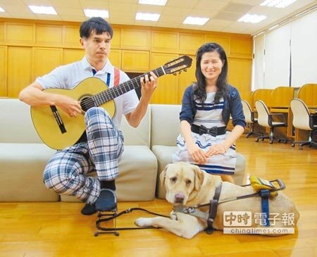 
　有你真好　　全盲辜進心（左）主修古典吉他，與視障妻子呂千毓（右）帶導盲犬瑞斯（前）赴日深造，返國推廣點字樂譜。（呂素麗攝）
 