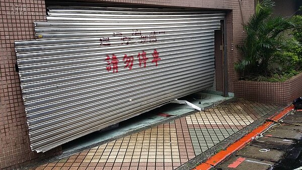 車庫鐵捲門抵擋不住狂風暴雨的摧殘,幾乎快要掀起來了。(網友提供)
