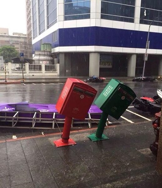 蘇迪勒颱風來襲，強風吹落的招牌，將郵筒打到「歪腰」。（翻攝自王宗弘臉書）