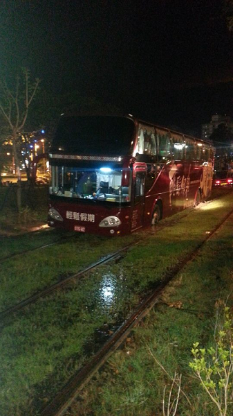 司機疑似路況不熟誤闖,結果遊覽車卡在軌道上動彈不得。(翻攝自爆料公社)