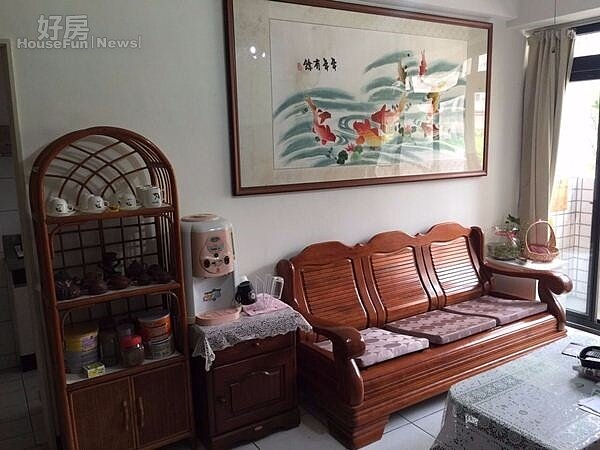 4.牆上以「年年有餘」畫作佈置,搭配木質沙發展現樸實感。