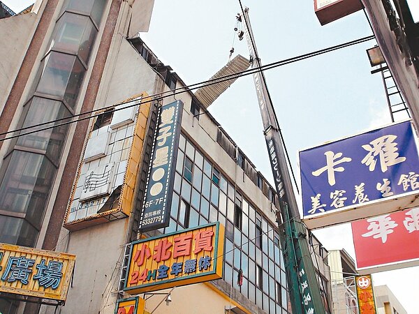 斗六市斗六門商業大樓頂樓遮雨棚鐵片,卡在8樓隨時有掉落危險,市公所出動吊車移除,避免釀災。 記者陳雅玲/攝影