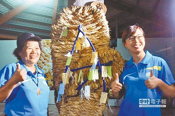國立東華大學同學們寫下傳遞祝福小卡片，懸掛在特製的大草鞋上。水土保持局花蓮分局長陳淑媛（左）及東華大學老師韓毓琦共同祈福。（楊漢聲翻攝）