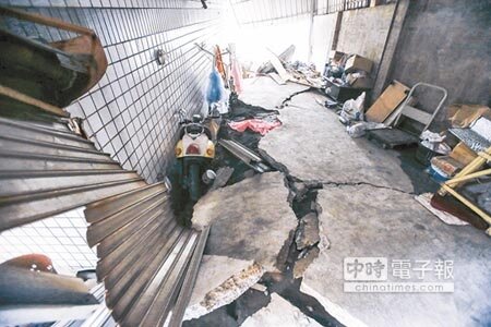 
陷入困境↑安南區惠安街民宅因土壤液化嚴重下陷，機車陷在裂縫中。（黃仲裕攝）
 