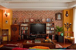 不愛工整的刻板，所以阮春華特別到磚塊工廠一塊塊挑選缺角的、燒壞的磚頭來堆砌客廳的電視牆，而且在磚塊與磚塊之間留白縫，為牆面注入溫暖的手感。