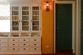 利用與天花相同的白，往下延伸，在用餐區規畫大量的展示兼收納空間，並在櫃體中央開一扇窗，沒有做滿整個壁面，適度的留白，是營造無壓感的小秘訣。