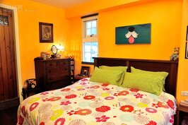 主臥延續明亮溫暖的黃色，營造放鬆的舒眠空間。