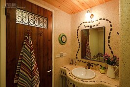 主臥浴室的洗手台鋪上抿石子，鵝卵石則沿著鏡面及檯面繞行，透露著不規則的隨興。